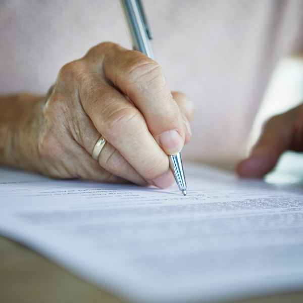 Persona firmando su herencia en un bufete de abogados especializado en herencias